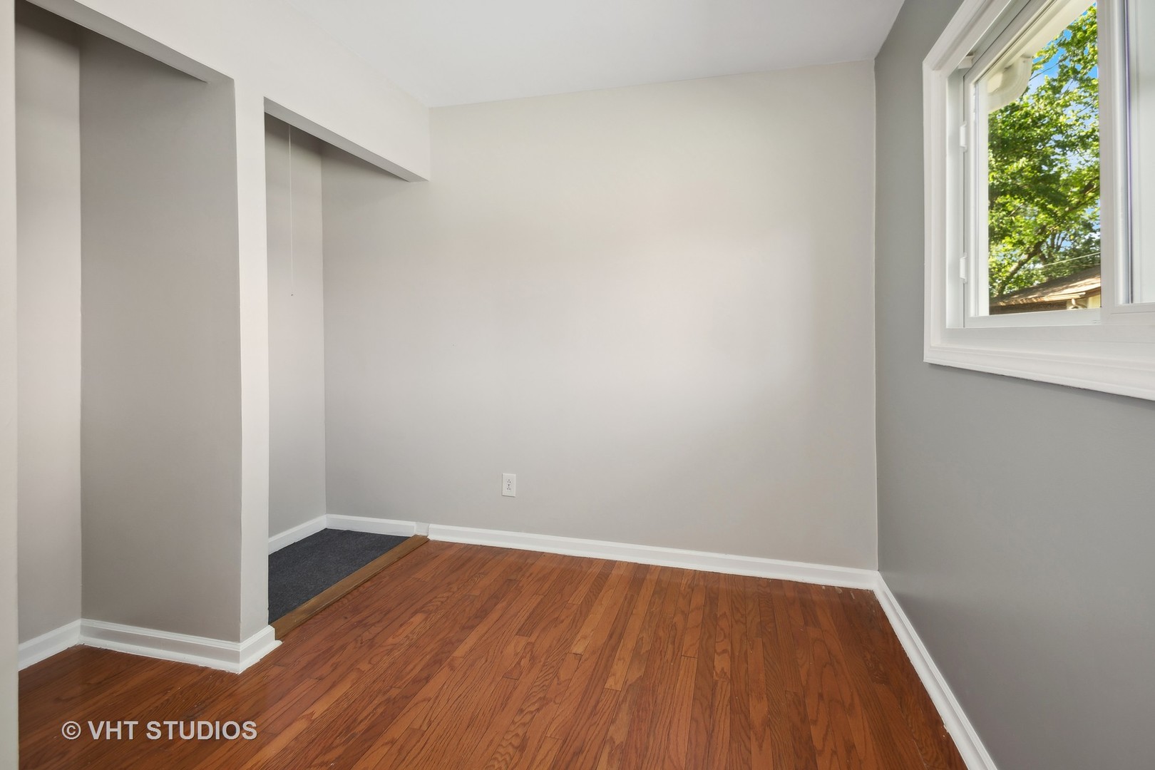 412 Cahill Road Streamwood, IL 60107 - Photo 11 of 16 a view of an empty room with wooden floor and a window