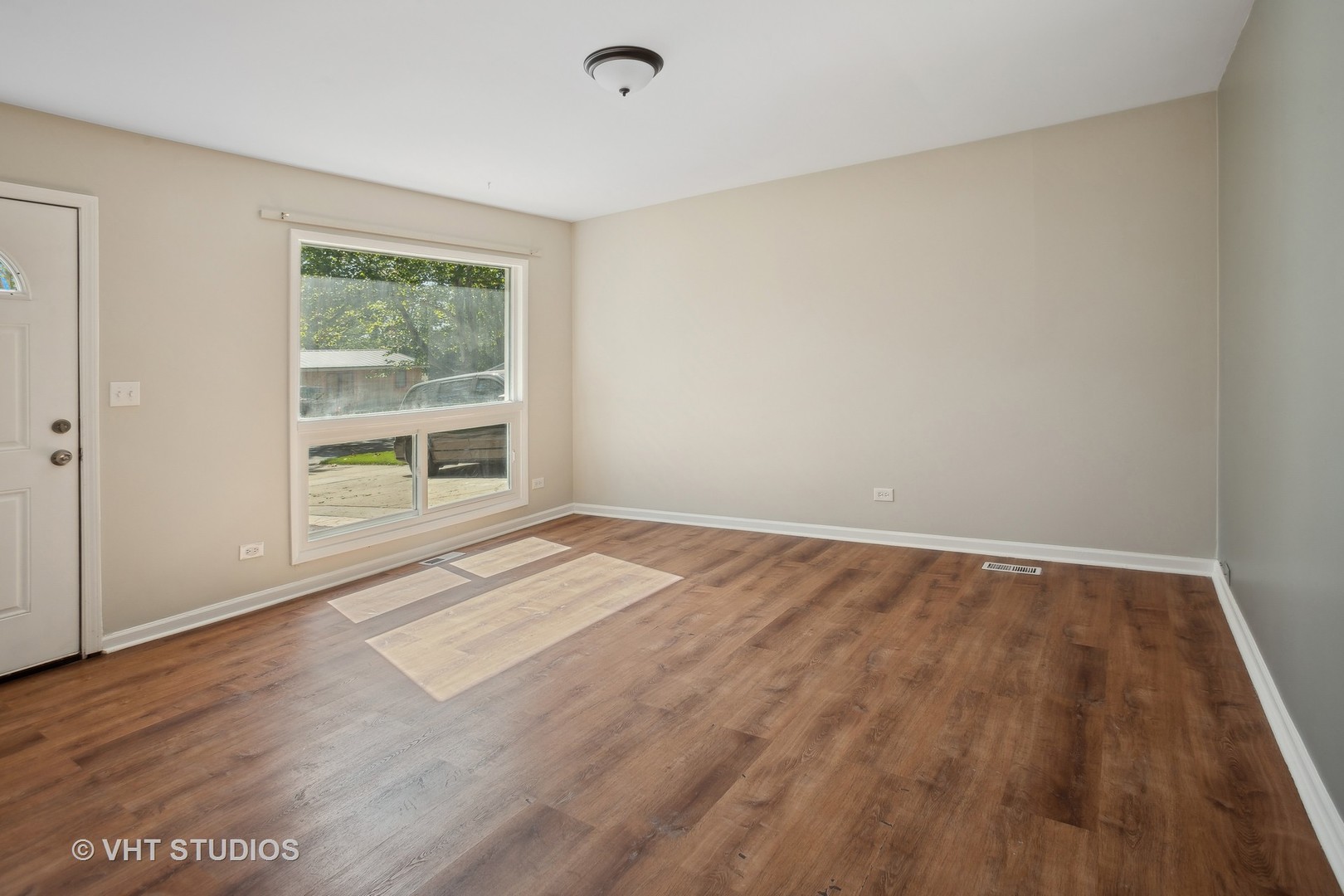 412 Cahill Road Streamwood, IL 60107 - Photo 3 of 16 an empty room with wooden floor and windows