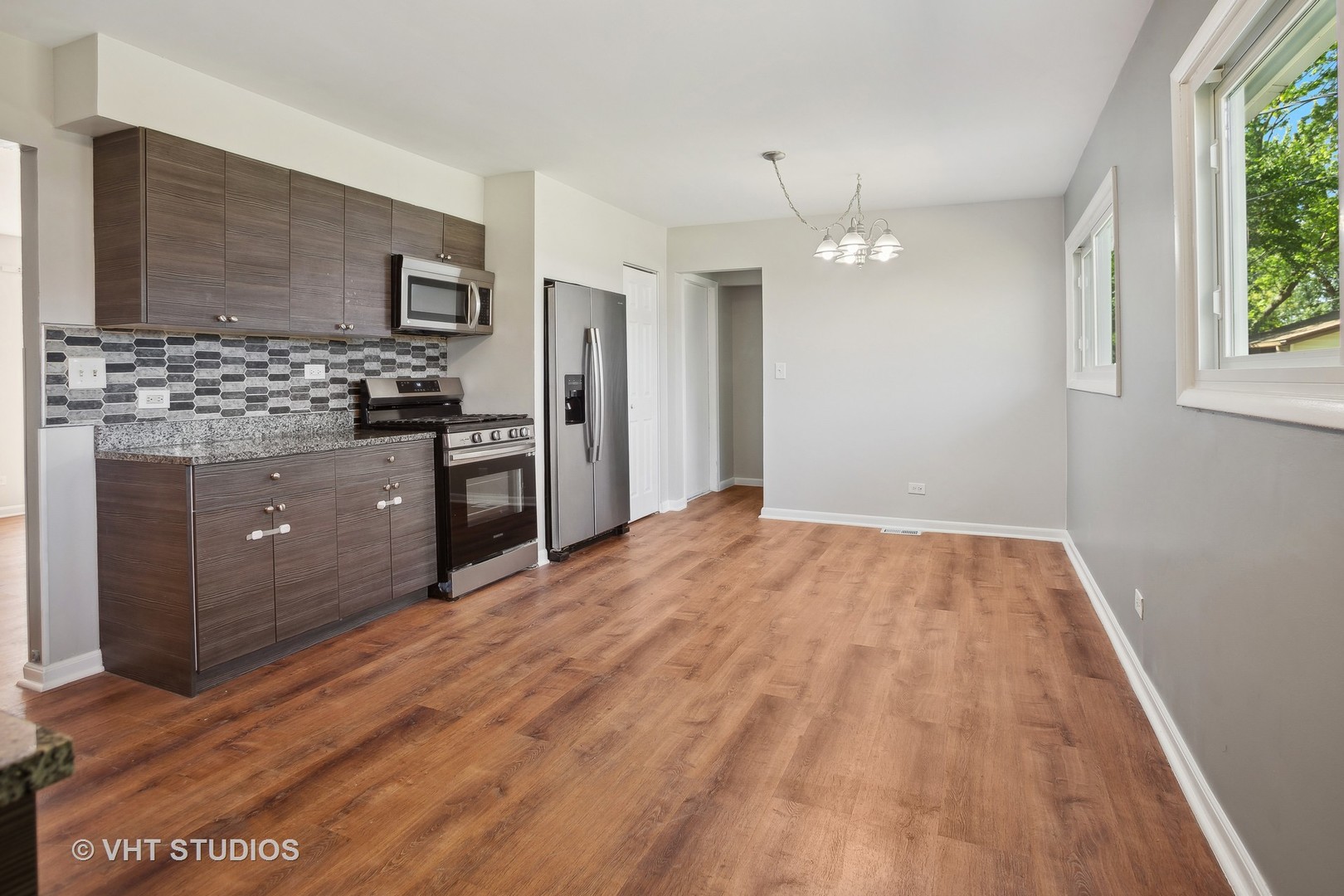 412 Cahill Road Streamwood, IL 60107 - Photo 5 of 16 a kitchen with granite countertop a refrigerator and a stove top oven