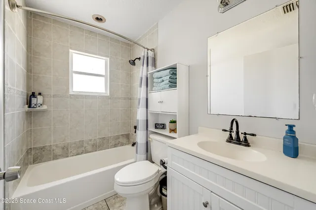 a bathroom with a sink a toilet a mirror a bathtub and shower