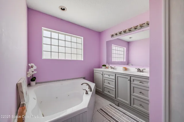 a bathroom with a tub sink and mirror