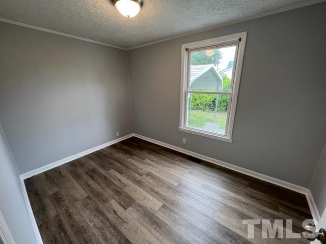 301 North 16th Street Erwin, NC 28339 - Photo 11 of 21 an empty room with wooden floor and windows