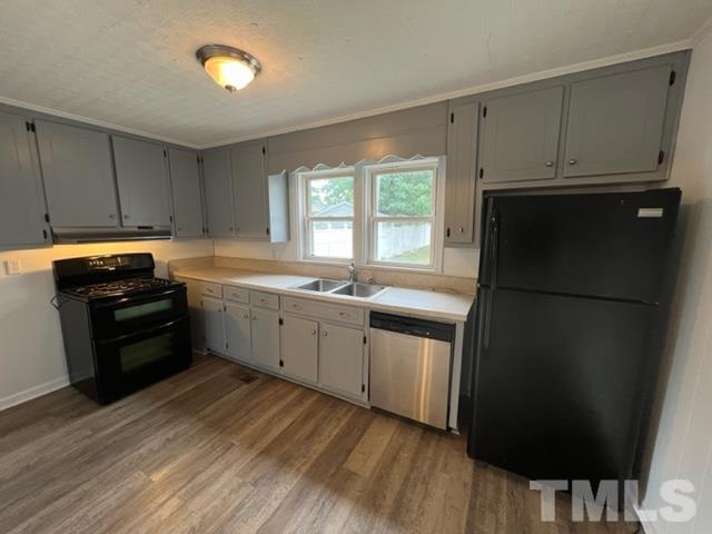 301 North 16th Street Erwin, NC 28339 - Photo 3 of 21 a kitchen with stainless steel appliances a refrigerator sink and cabinets