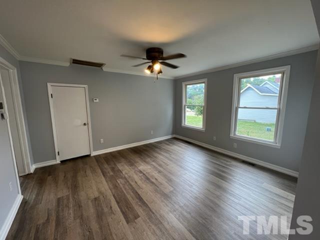 301 North 16th Street Erwin, NC 28339 - Photo 7 of 21 an empty room with wooden floor chandelier fan and windows