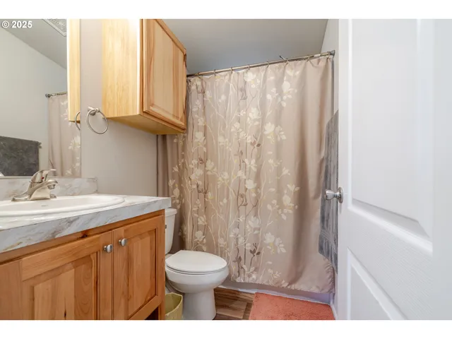 a bathroom with a granite countertop sink toilet and shower