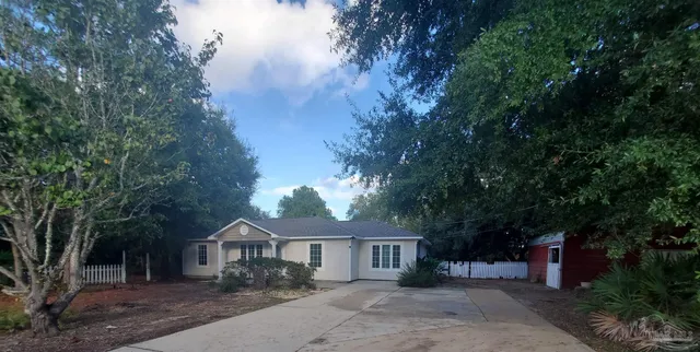 a front view of a house with a yard and tree s