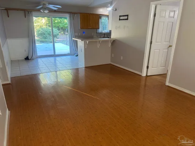 a view of a kitchen with wooden floor and a window