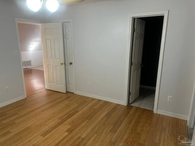 an empty room with wooden floor and closet