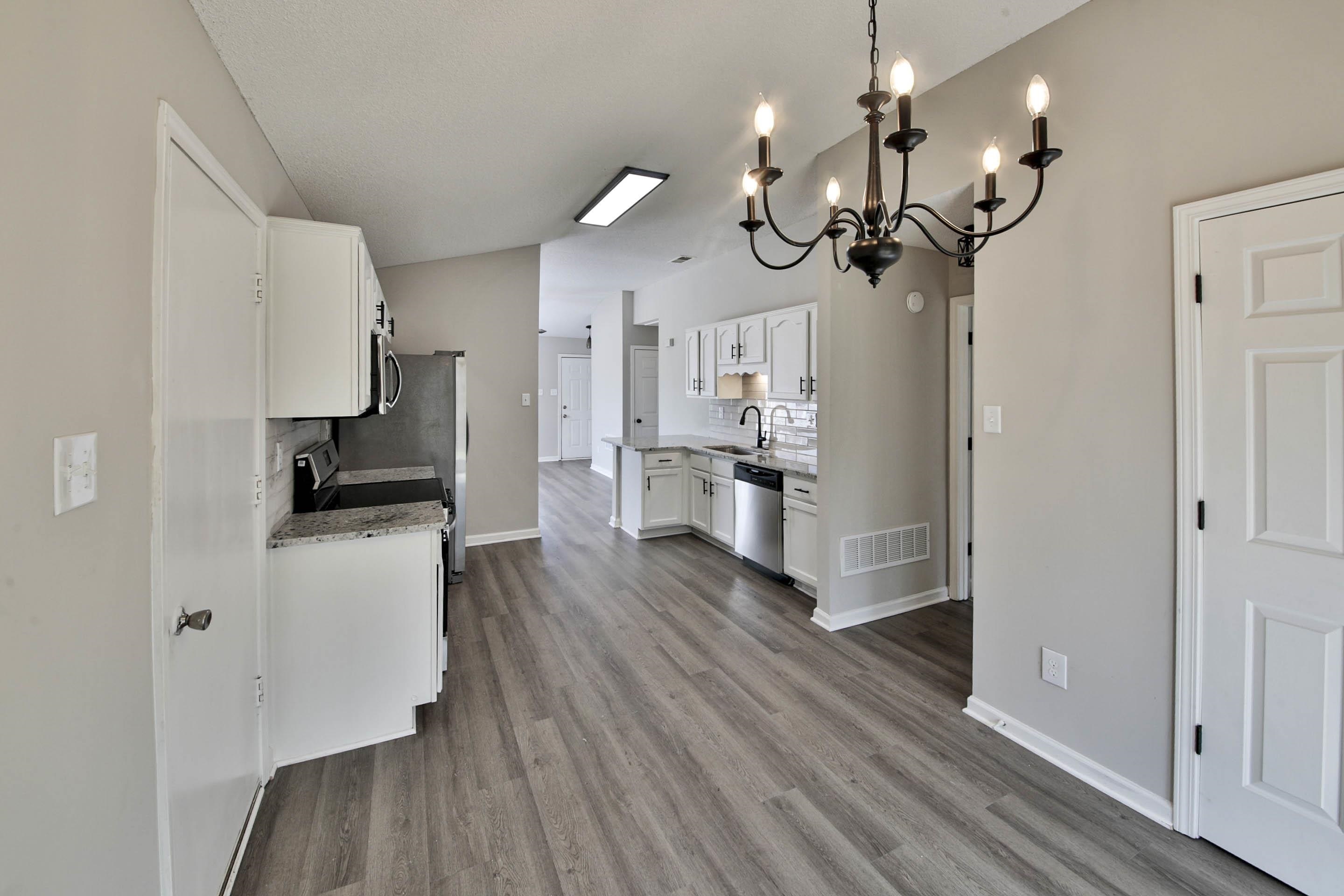 125 Pine Ridge Lane Oakland, TN 38060 - Photo 11 of 24 Kitchen with backsplash, white cabinets, a chandelier, light stone countertops, and stainless steel appliances