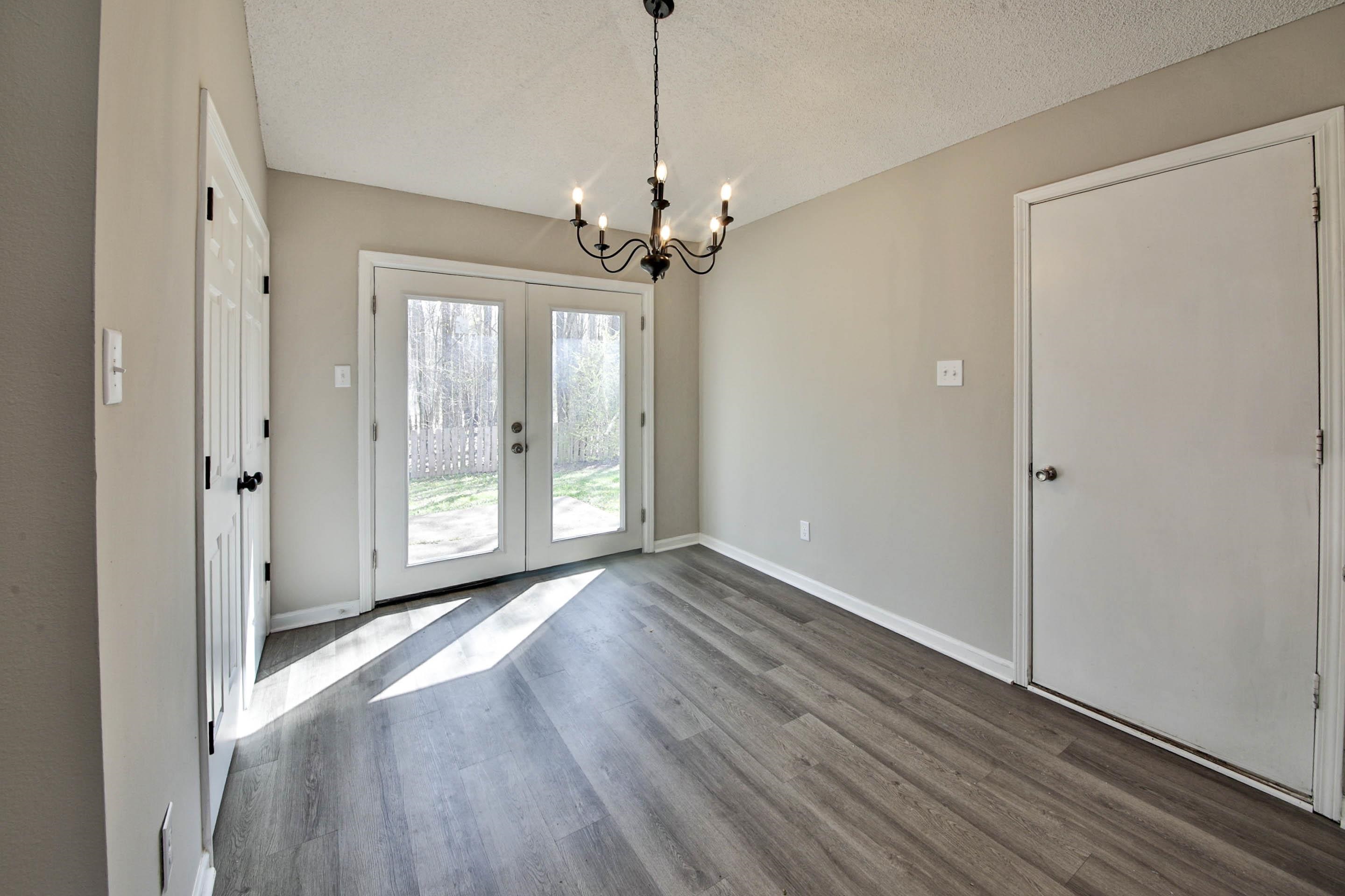 125 Pine Ridge Lane Oakland, TN 38060 - Photo 13 of 24 Unfurnished dining area with hanging lights, dark wood-type flooring, a textured ceiling, and french doors