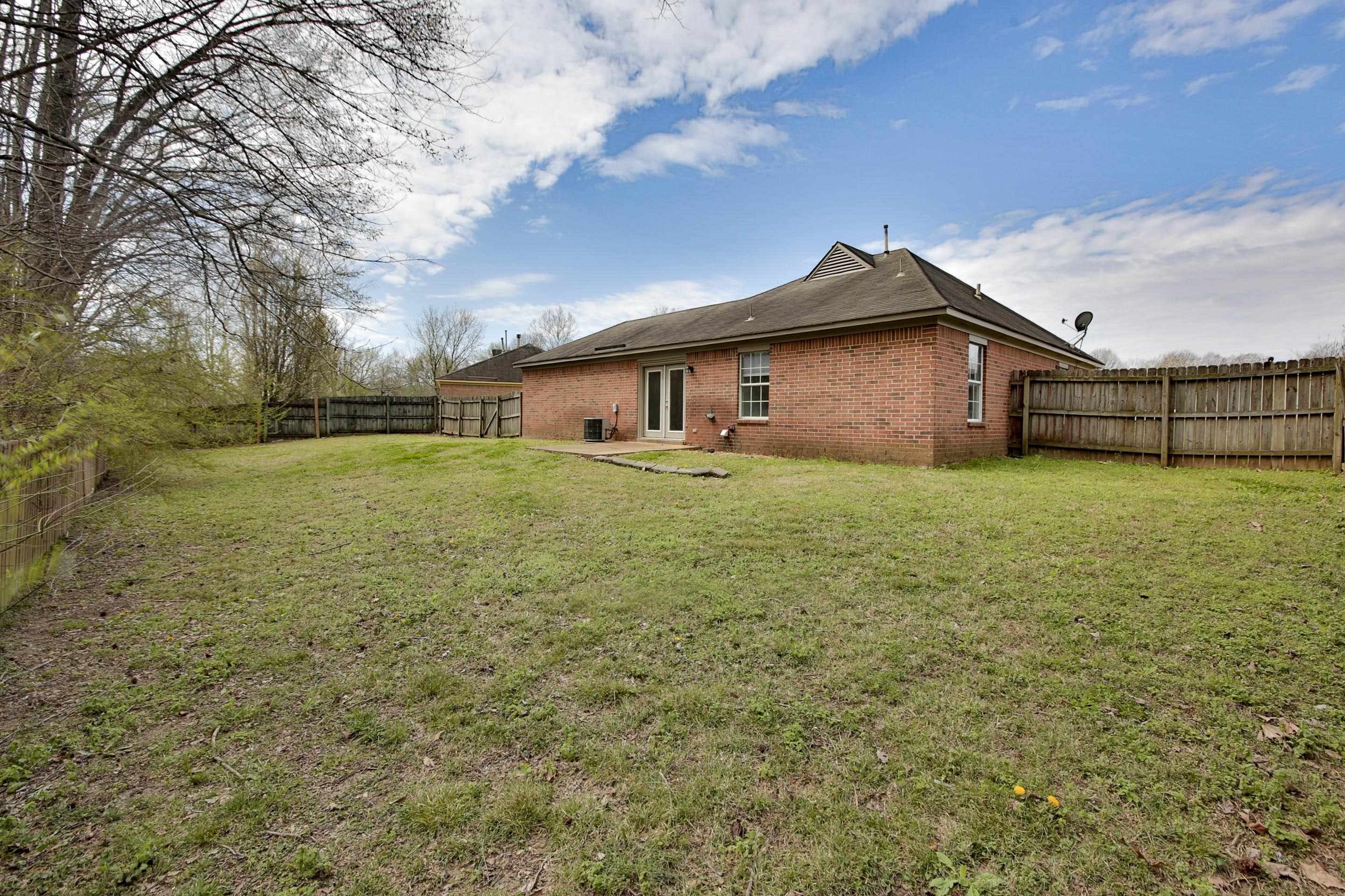 125 Pine Ridge Lane Oakland, TN 38060 - Photo 23 of 24 Back of house with brick siding, a patio area, and a fenced backyard