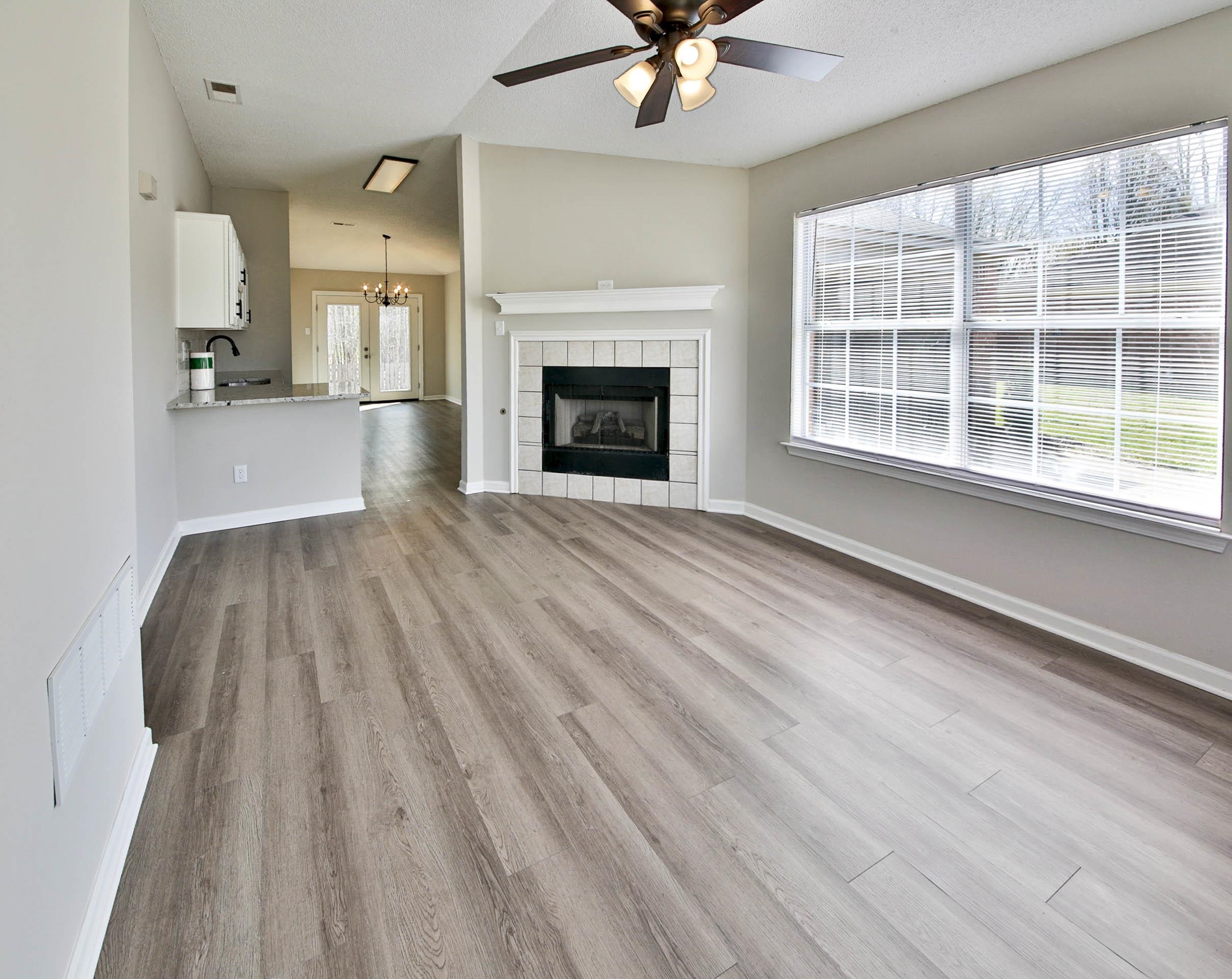125 Pine Ridge Lane Oakland, TN 38060 - Photo 3 of 24 Unfurnished living room with suspended lighting, light wood finished floors, ceiling fan, and a fireplace