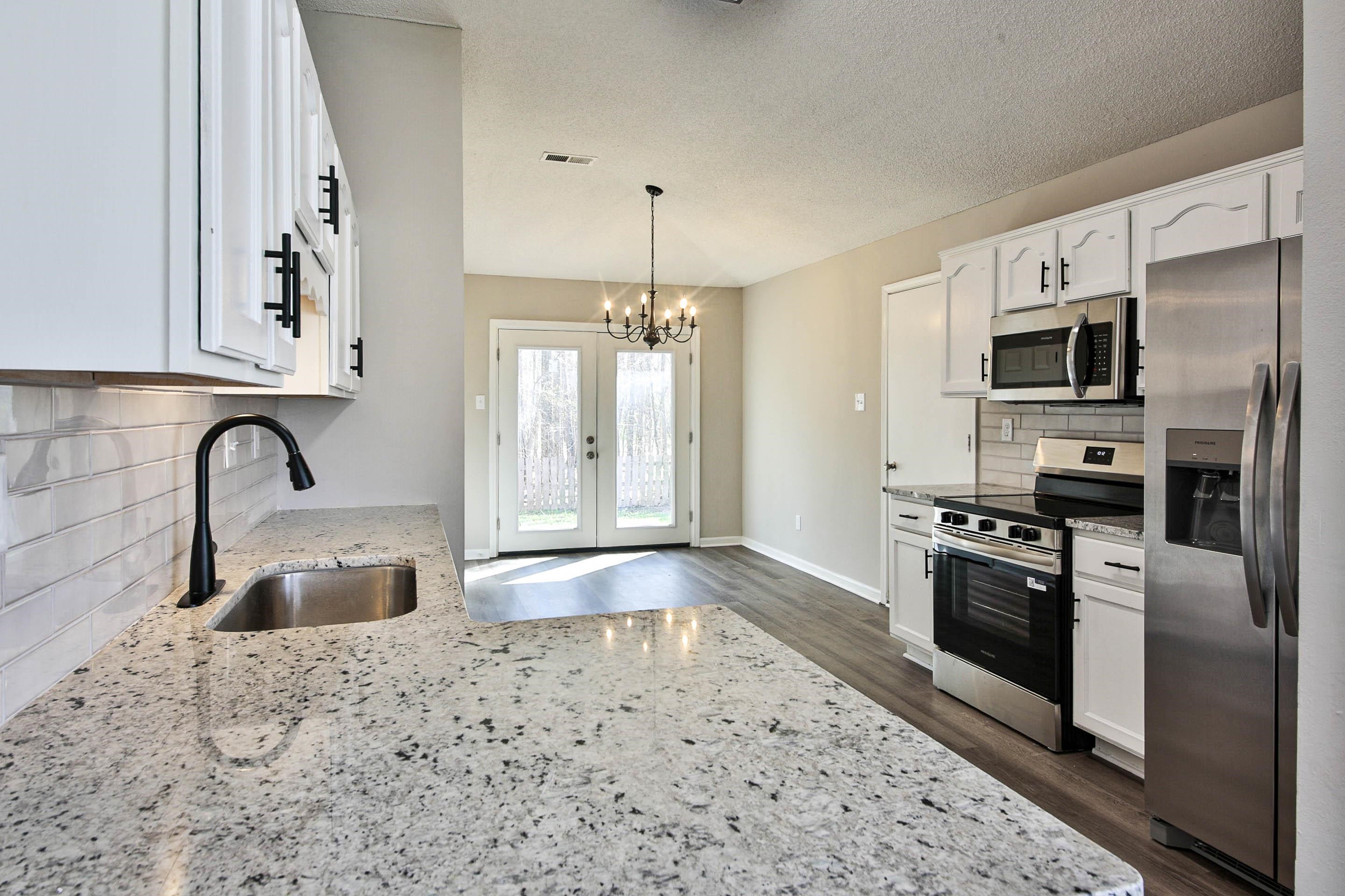125 Pine Ridge Lane Oakland, TN 38060 - Photo 7 of 24 Kitchen with tasteful backsplash, stainless steel appliances, white cabinetry, light stone countertops, and hanging lights