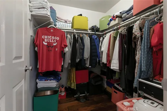 a view of walk in closet with clothes and shoes