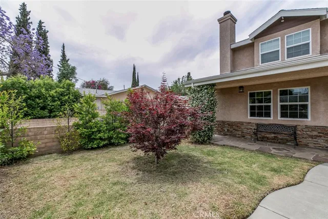 a view of a house with a yard and sitting area