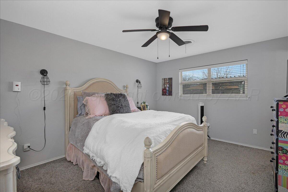 6912 Manor Circle Amarillo, TX 79109 - Photo 13 of 25 a bedroom with a bed and a chandelier