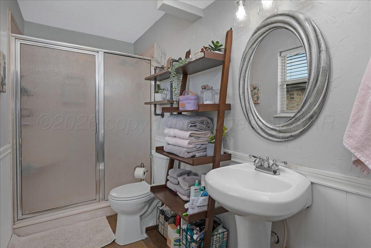 6912 Manor Circle Amarillo, TX 79109 - Photo 15 of 25 a bathroom with a sink a toilet and a mirror