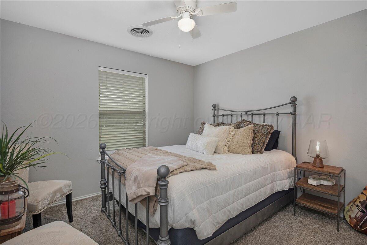 6912 Manor Circle Amarillo, TX 79109 - Photo 16 of 25 a bedroom with a bed and a chandelier
