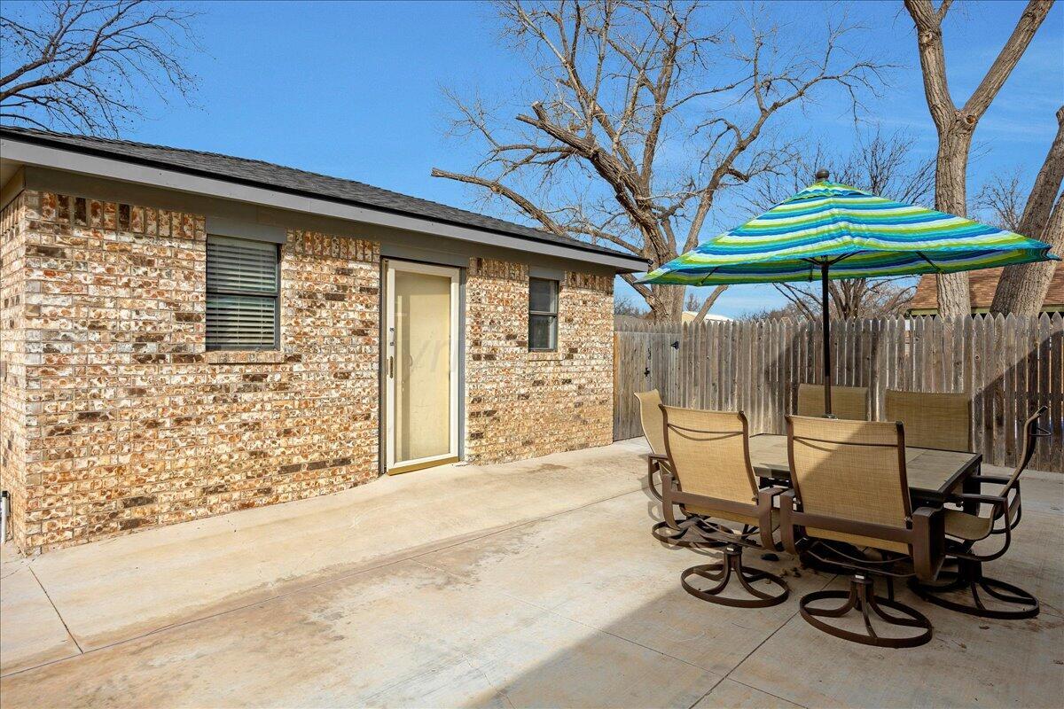 6912 Manor Circle Amarillo, TX 79109 - Photo 21 of 25 a view of a patio with table and chairs under an umbrella