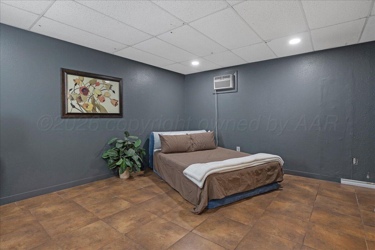 6912 Manor Circle Amarillo, TX 79109 - Photo 22 of 25 a spacious bedroom with a bed and a painting on the wall