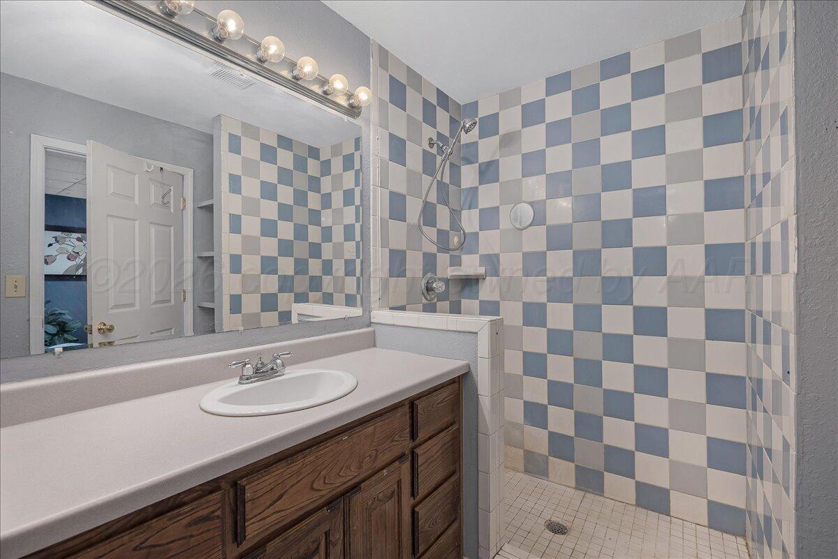6912 Manor Circle Amarillo, TX 79109 - Photo 23 of 25 a bathroom with a sink and a mirror