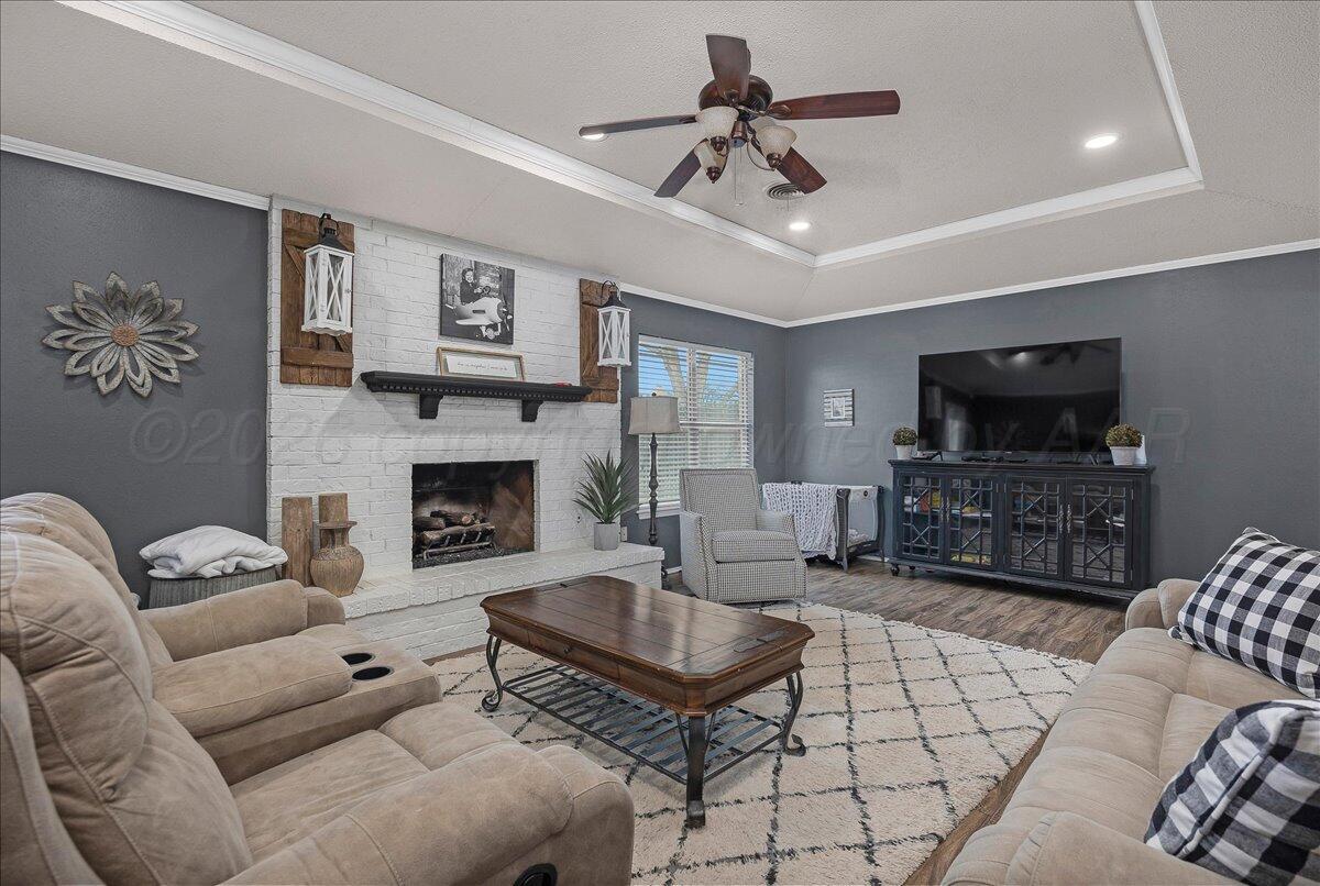 6912 Manor Circle Amarillo, TX 79109 - Photo 4 of 25 a living room with furniture a flat screen tv and a fireplace