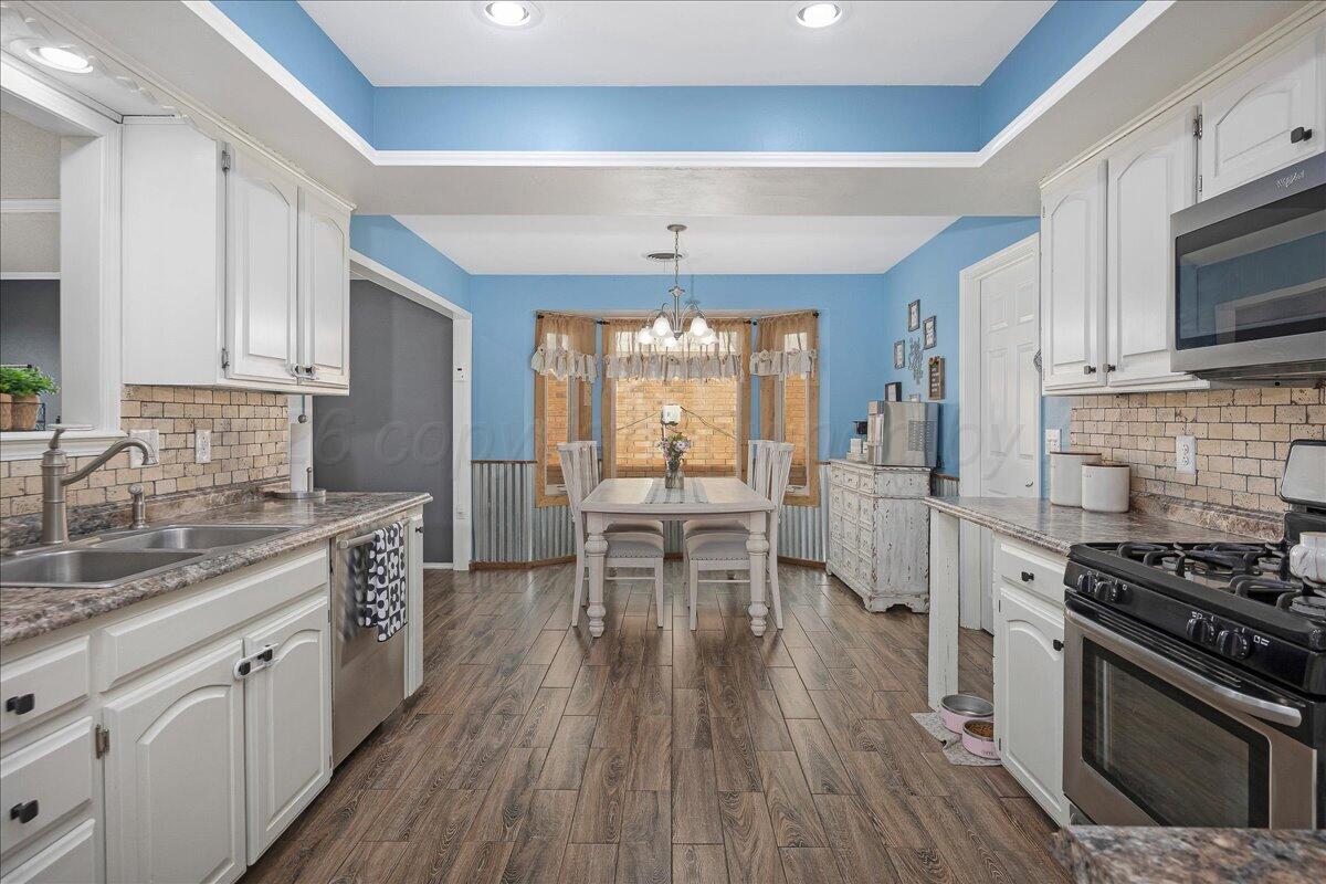 6912 Manor Circle Amarillo, TX 79109 - Photo 8 of 25 a kitchen with a stove a sink and wooden cabinets