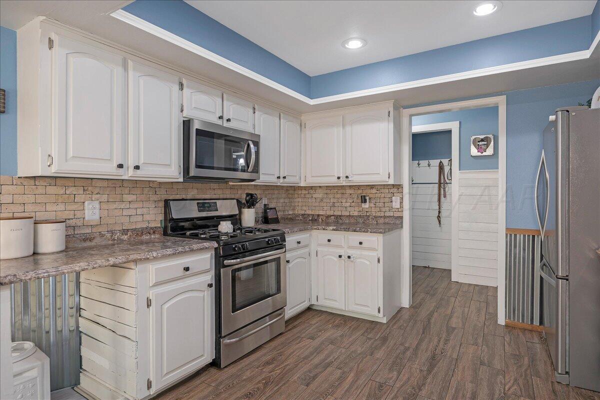 6912 Manor Circle Amarillo, TX 79109 - Photo 10 of 25 a kitchen with stainless steel appliances granite countertop a stove a sink and a refrigerator