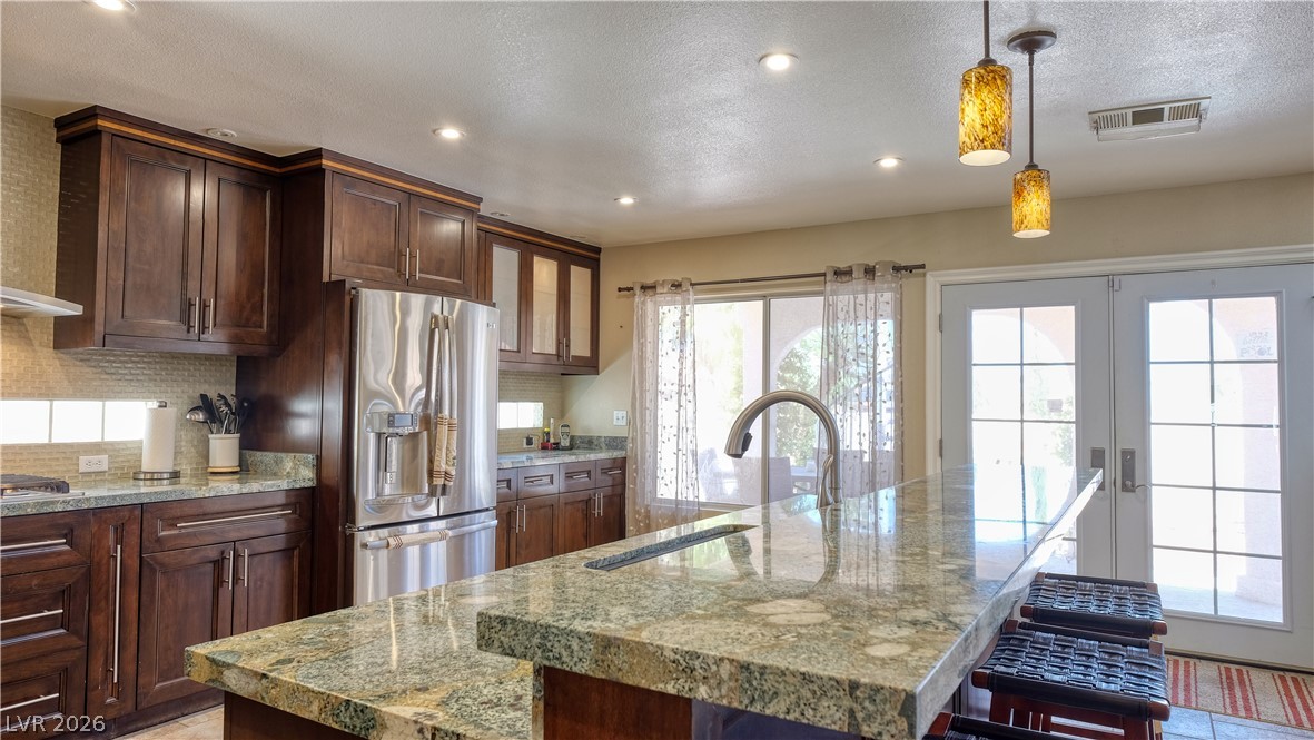 3704 North Campbell Road Las Vegas, NV 89129 - Photo 3 of 38 Granite counters and stainless steel appliances complete this spacious, well-lit kitchen with outdoor access.