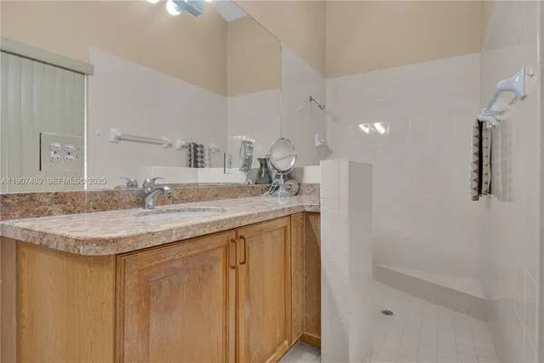 a bathroom with a granite countertop sink and a mirror