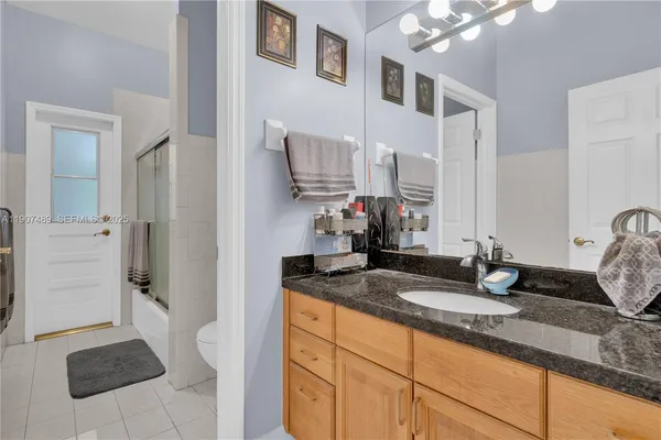 a bathroom with a granite countertop sink and a mirror