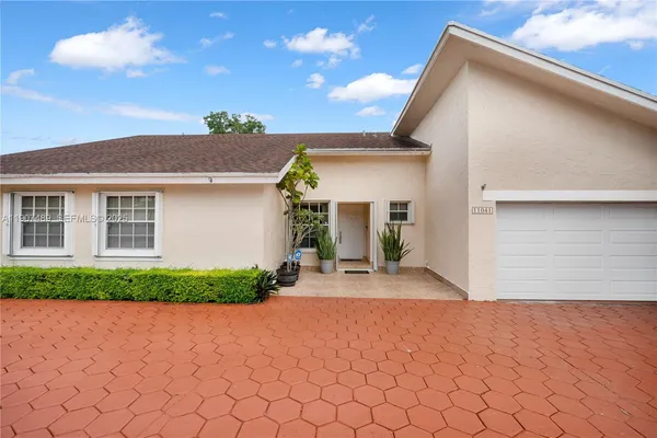 a view of a house with a yard and potted plants