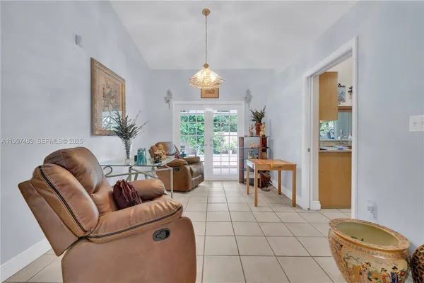 a living room with furniture a dining table and a chandelier