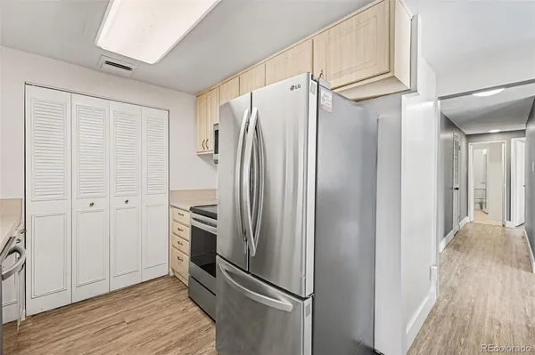 a view of a refrigerator in kitchen and wooden floor
