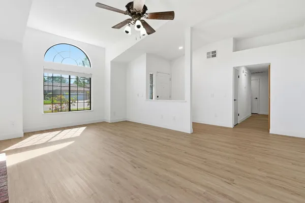 a view of empty room with wooden floor and window