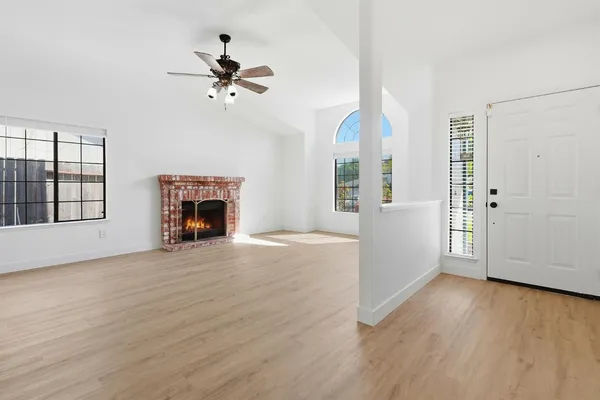 a view of an empty room with a window and fireplace