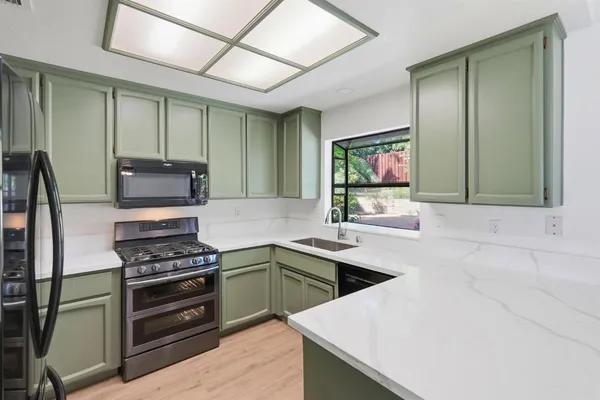 a kitchen with stainless steel appliances a stove sink and microwave