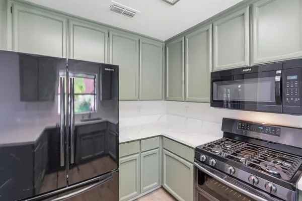 a kitchen with granite countertop a stove and a refrigerator