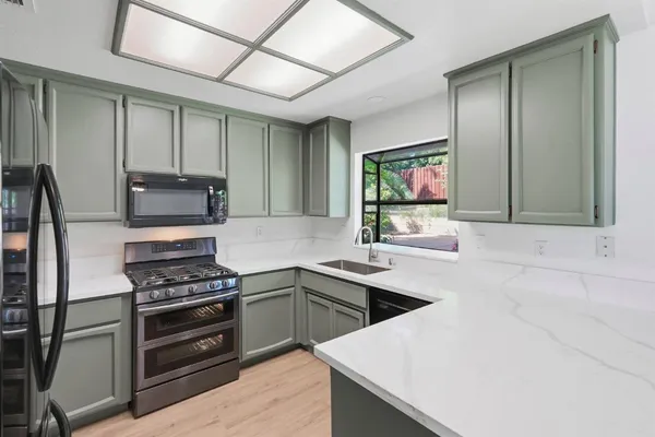 a kitchen with stainless steel appliances a stove sink and microwave