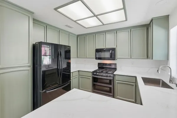 a kitchen with stainless steel appliances granite countertop a refrigerator stove and sink