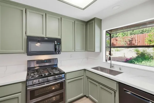 a kitchen with a sink stove top oven and cabinets