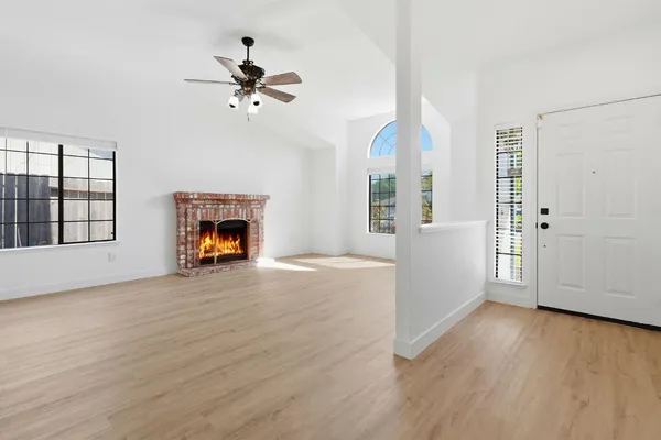 an empty room with windows and fireplace