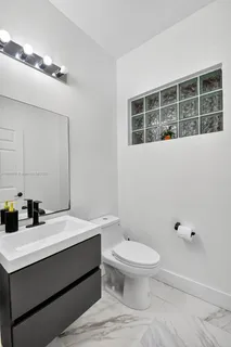 a white toilet sitting next to a bathroom sink