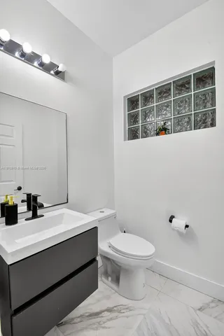 a white toilet sitting next to a bathroom sink