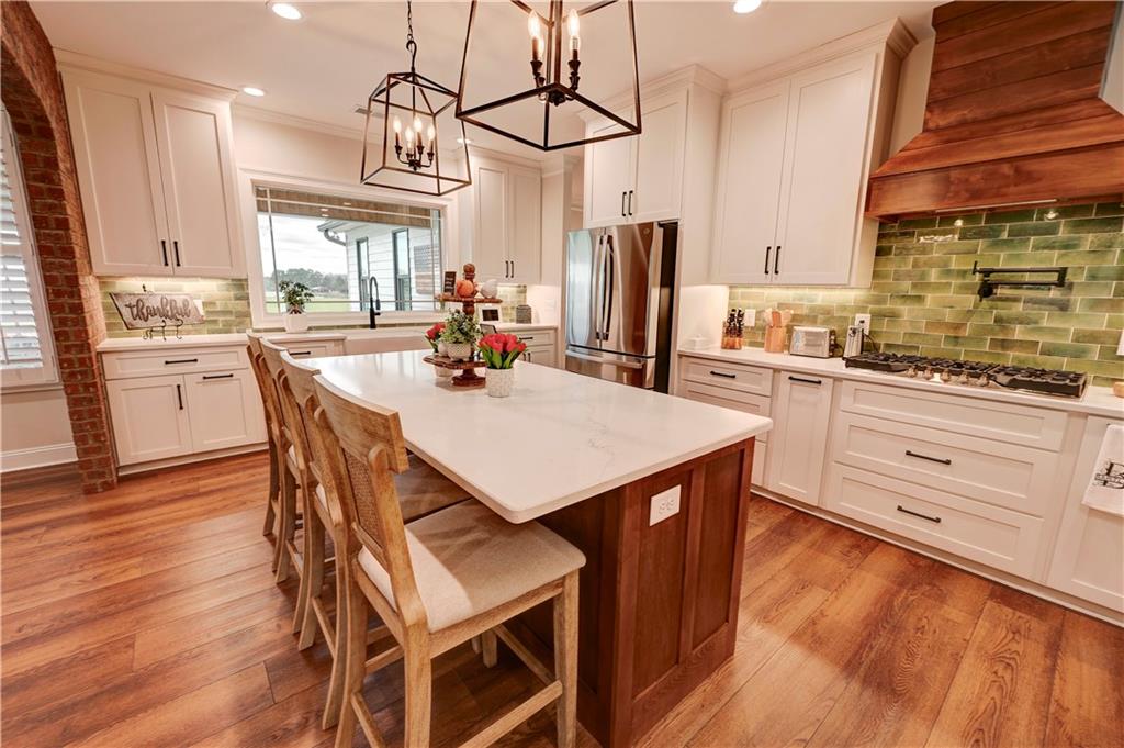 2453 Boone Ford Road Southeast Calhoun, GA 30701 - Photo 33 of 135 a kitchen with stainless steel appliances a table chairs refrigerator and cabinets