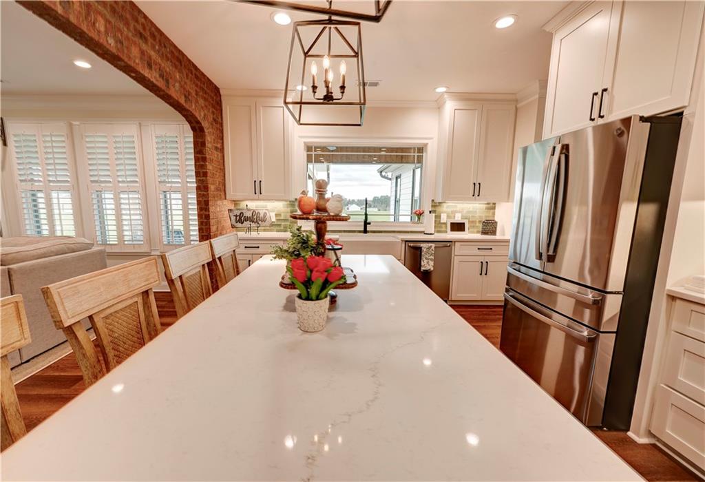2453 Boone Ford Road Southeast Calhoun, GA 30701 - Photo 35 of 135 a kitchen with stainless steel appliances a refrigerator a sink a stove a dining table and chairs