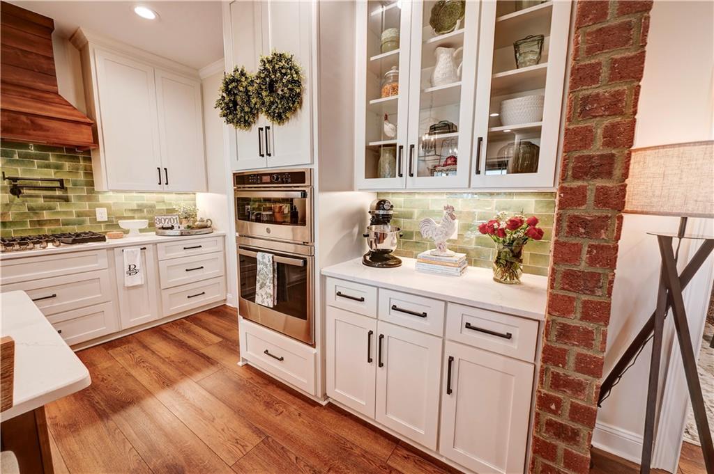 2453 Boone Ford Road Southeast Calhoun, GA 30701 - Photo 47 of 135 a kitchen with stainless steel appliances white cabinets and wooden floors