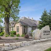 a view of a white house with a yard and large tree