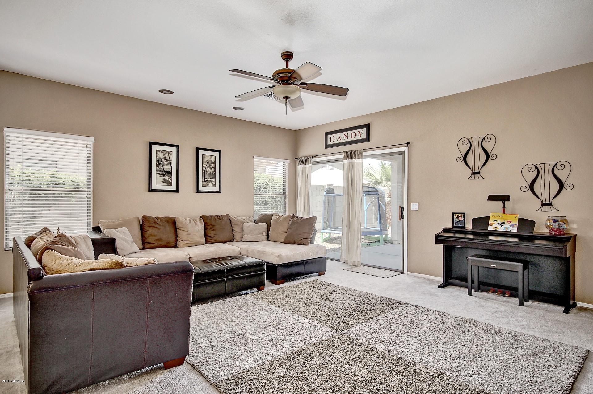 14620 West Redfield Road Surprise, AZ 85379 - Photo 9 of 32 a living room with furniture and a chandelier