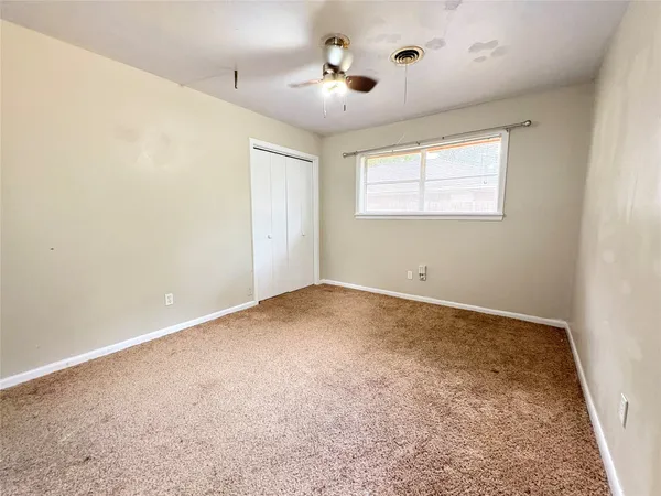en empty room with windows and ceiling fan